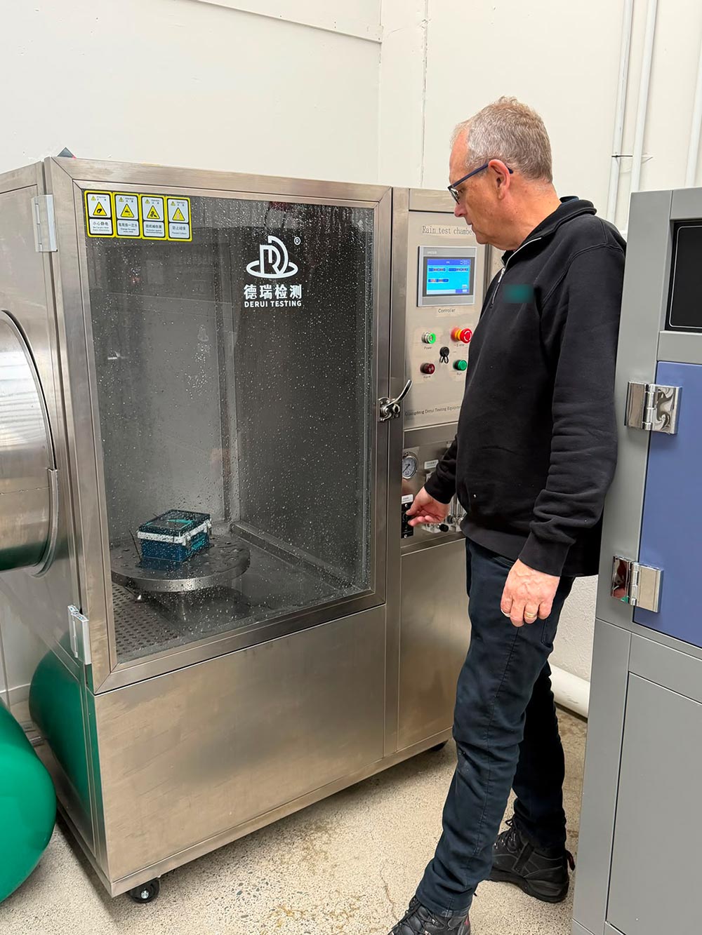 Guangdong Derui IPX56 rain test chamber with touchscreen controller in operation at a New Zealand client laboratory
